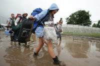 Pobol yn dechrau cyrraedd gŵyl Glastonbury yng nghanol y mwd