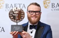 Huw Stephens gyda'i wobr BAFTA Cymru