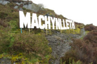 Arwydd 'Machynlleth' uwchben y dref