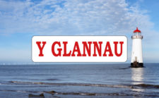Logo papur bro Y Glannau gyda llun o oleudy